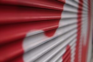 Closeup shot of an abstract red and white graffiti on a folding metal gate outdoors