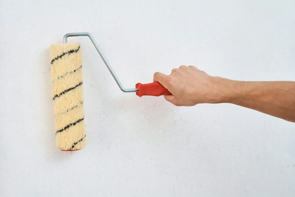 Man painting wall with paint roller